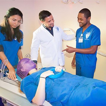 radiation therapy students wearing scrubs in lab with professor