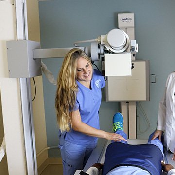 female radiologic technologist working with patient