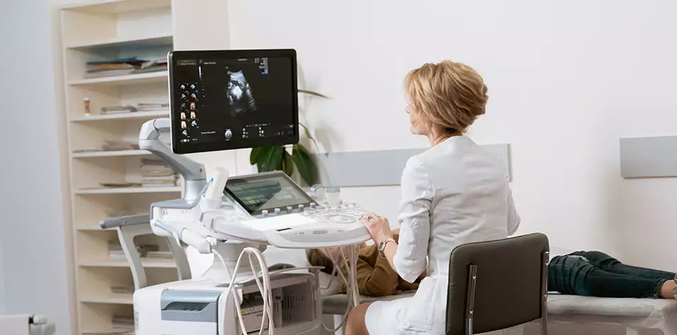 A female diagnostic medical sonographer is looking at a sonograph