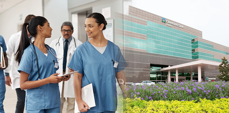 Cambridge College nursing students are walking on campus and talking in their blue scrubs